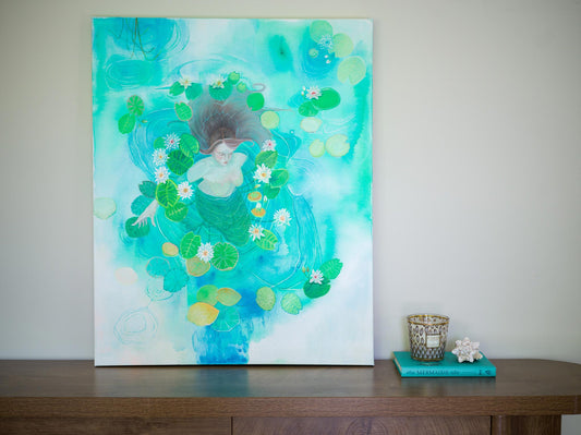A canvas painting featuring a whimsical underwater scene with a mermaid surrounded by green lily pads and white flowers